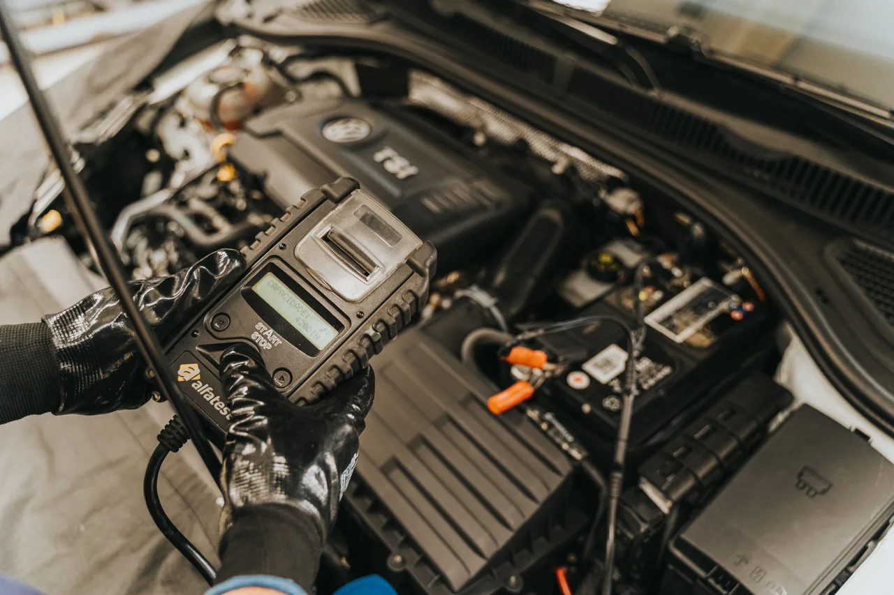 Diagnosegerät und Motorraum bei einer technischen Fahrzeugprüfung